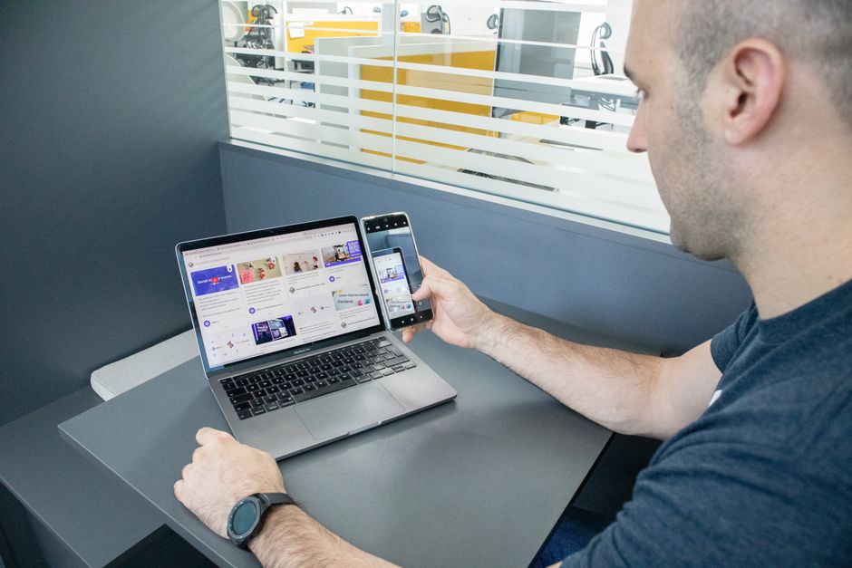 Čovjek koristi laptop i smartphone u suvremenom uredskom prostoru