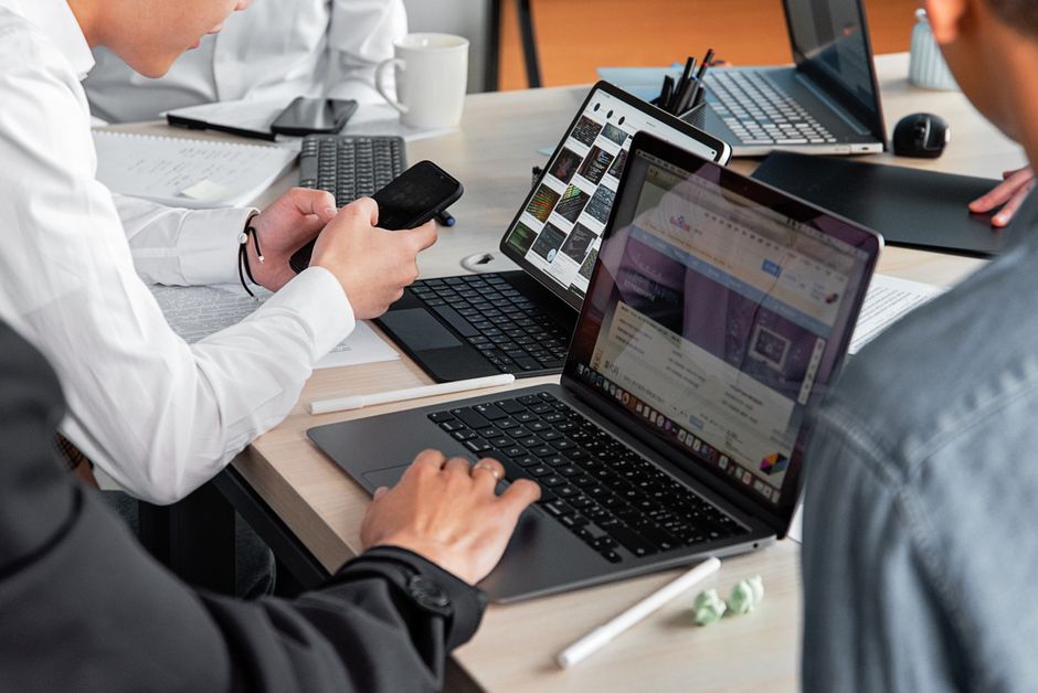 Profesionalci u modernom uredu razgovaraju o poslu s laptopima i pametnim telefonima