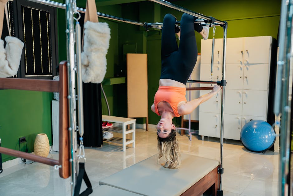 Adult woman doing an upside-down pose on a reformer pilates machine