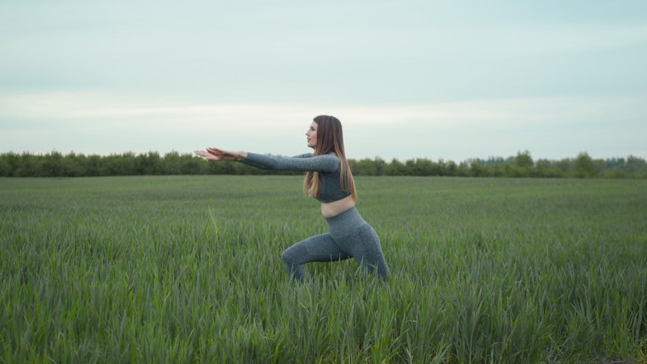 Woman practicing yoga in a green field, enjoying nature and freedom in Львів, Ukraine
